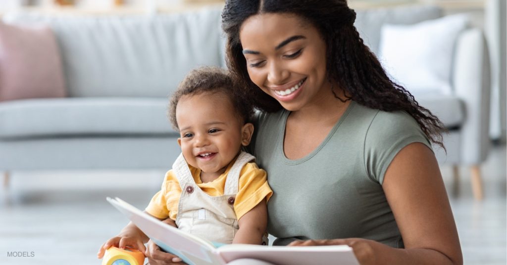 middle-aged mom holding her son looking at a book (models)