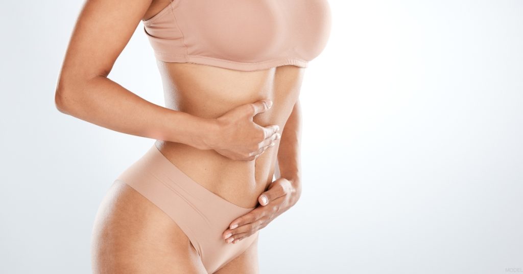 a woman with her hands on their stomach (model)