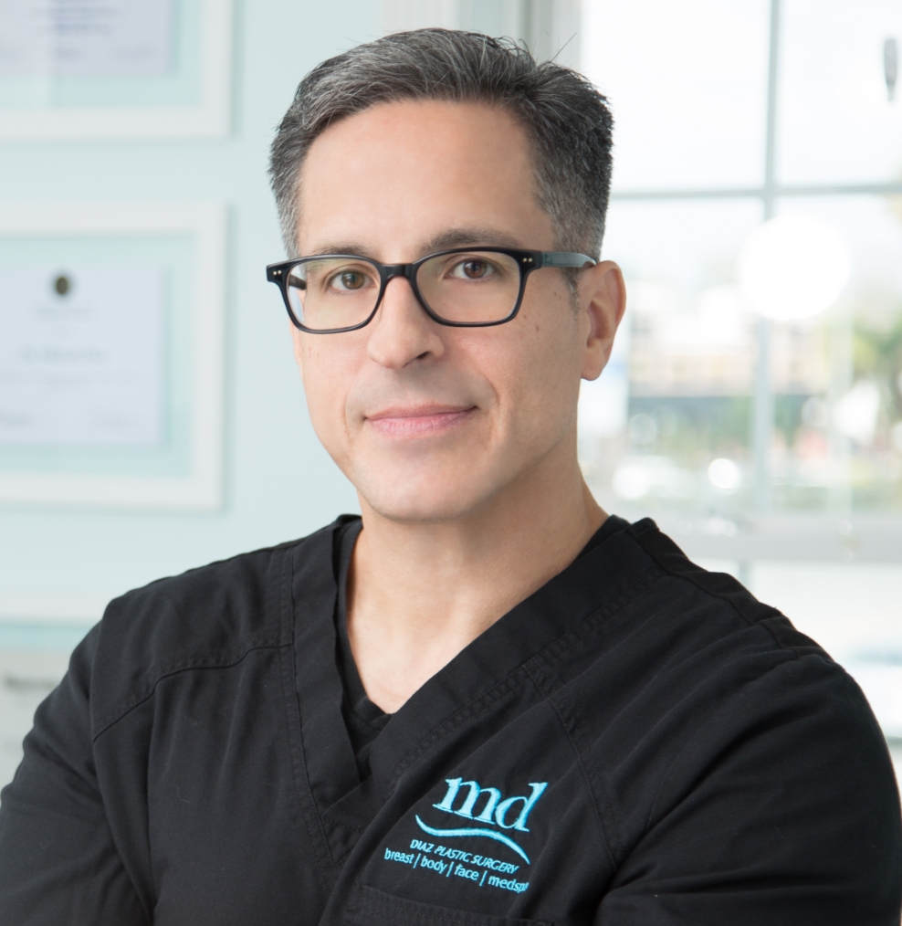 Headshot of Dr. Diaz wearing glasses and black scrubs with MD logo